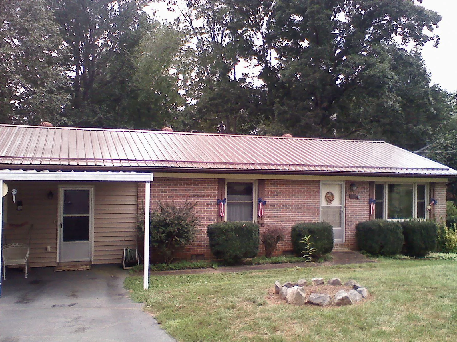 Bronze metal roof and carport on a brick ranch home — Roof Repair work by our crew in Clarks Grove